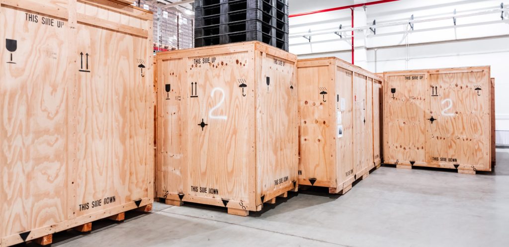 Wooden boxes in the warehouse. Boxes out of wood for packing industrial machinery. Warehousing. Packaging of finished products of the plant. Sale of packaging materials.